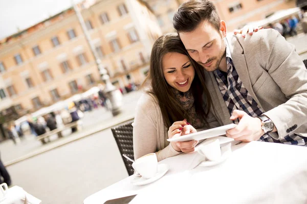 Casal amoroso olhando para o tablet em um café em Roma — Fotografia de Stock