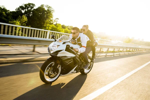 Genç adam ve bir kadın bir motosiklet üzerinde