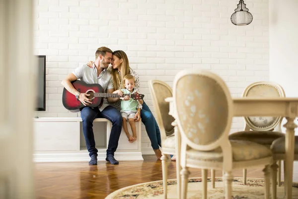 Preciosa pareja joven con guitarra en la habitación — Foto de Stock