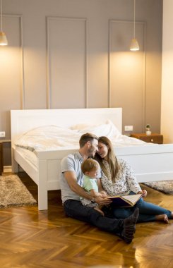 Mutlu genç aile yerde kitapla