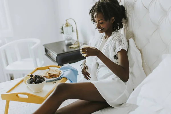 Sorrindo afro-americana tendo um café da manhã relaxante — Fotografia de Stock