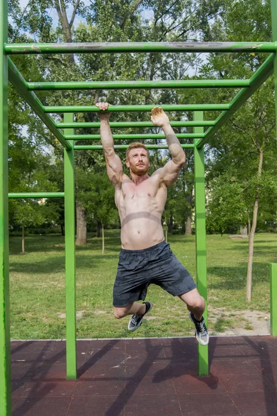Güçlü yooung adam parkta egzersiz