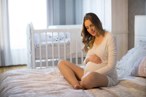 Беременная женщина в постели — стоковое фото