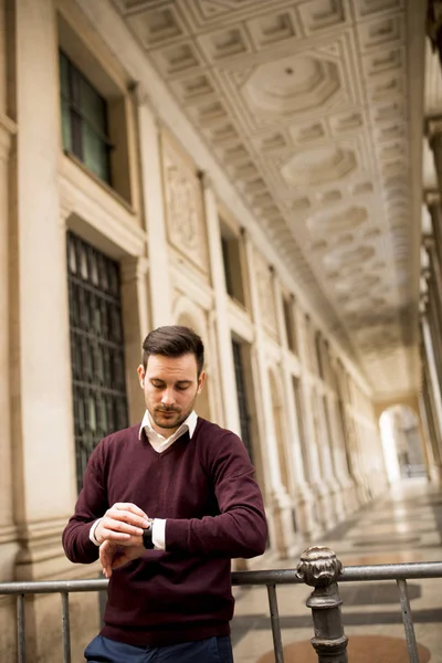 Yakışıklı adam rahat kıyafetler için beklerken zamanı denetleme