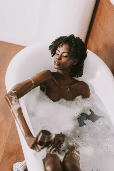 Giovane afro-americana giovane donna che posa in bagno con schiuma — Foto Stock