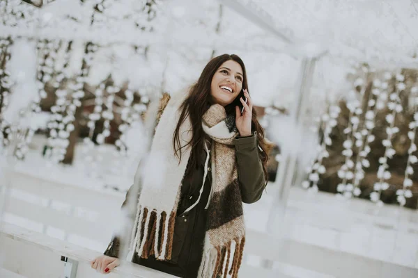 Jeune femme utilisant le téléphone dans le parc — Photo