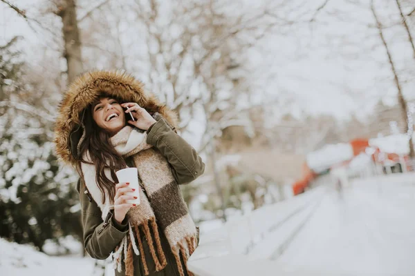 Parkta telefon kullanan genç kadın