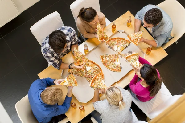 Anak muda makan pizza dan minum sari buah apel — Stok Foto