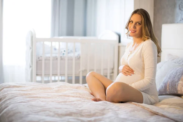 ベッドの上の妊娠中の女性 — ストック写真
