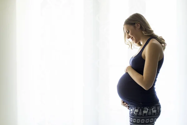 Femme enceinte par fenêtre — Photo