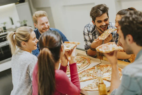 Молодые люди едят пиццу и пьют сидр — стоковое фото