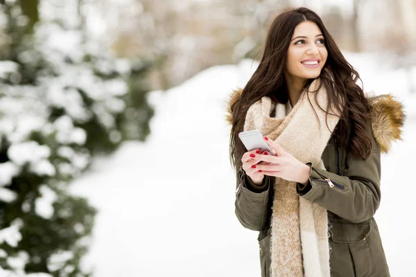 Smiling woman using phone in park — Stock Photo, Image