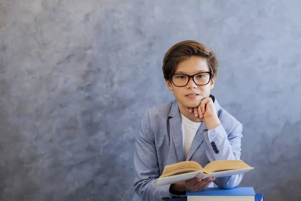 Netter Teenager mit Brille liest Buch — Stockfoto