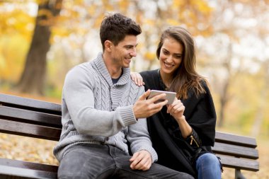 Genç çift mutlu bir smartphone cep telefonu ile bir şey izlemek