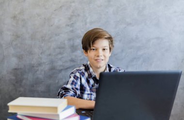 Dizüstü bilgisayarda çalışan bir genç yaş çocuk