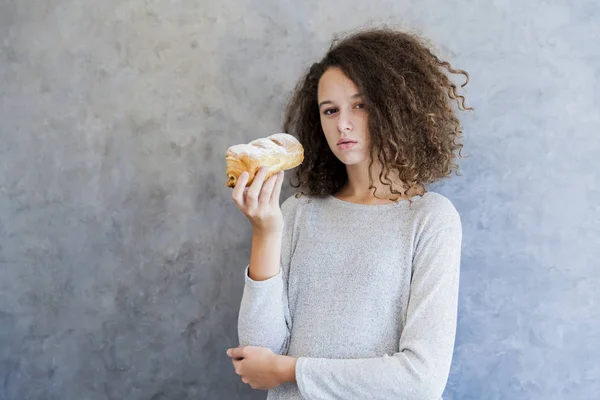 Genezen van krullend haar meisje eten croissant — Stockfoto