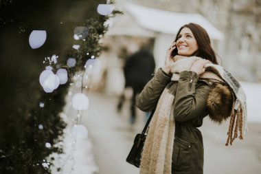 Gülümseyen kadın parkta telefon kullanma 