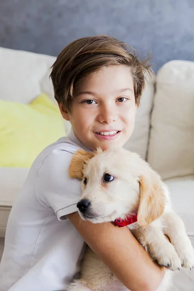 部屋のレトリーバー犬の赤ちゃんにかわいい十代の少年 — ストック写真