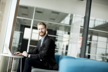 Kızıl saçlı genç işadamı laptop ya da defter üzerinde çalışma