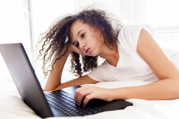 Cabello rizado adolescente gitl websurf internet en el ordenador portátil — Foto de Stock