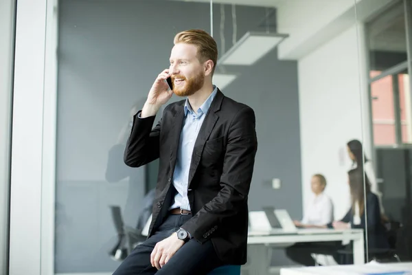 Homme d'affaires avec des cheveux de gingembre en utilisant le téléphone mobile tandis que d'autres busi — Photo