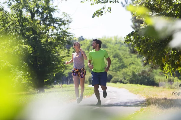 Coppia sportiva che corre nel parco — Foto Stock