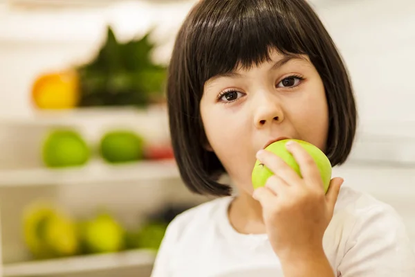 Lindo pelo negro niña comiendo manzana verde — Foto de Stock