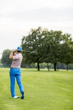 Golf sahasında golf oynayan adam.