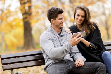 Genç çift mutlu bir smartphone cep telefonu ile bir şey izlemek