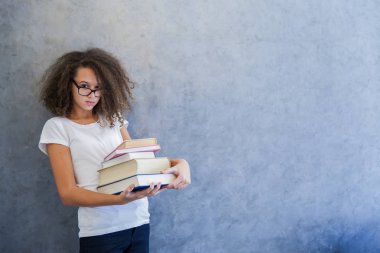 Gözlüklü genç kız ve birkaç kitap tutar