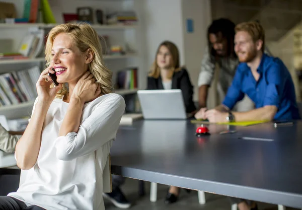 Geschäftsfrau mit Handy im Büro — Stockfoto