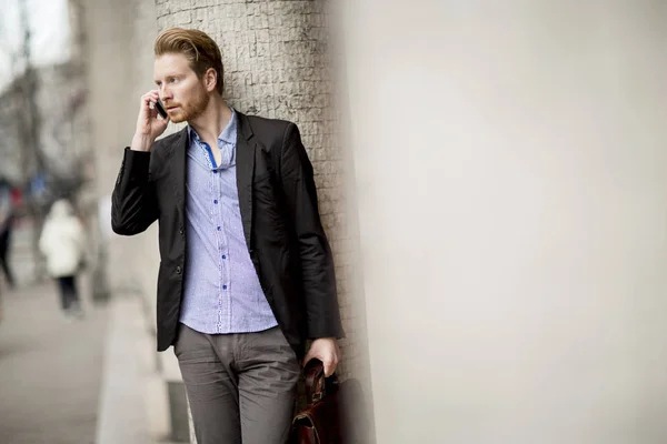 Uomo d'affari zenzero in attesa di trasporto e utilizzando il telefono cellulare — Foto Stock
