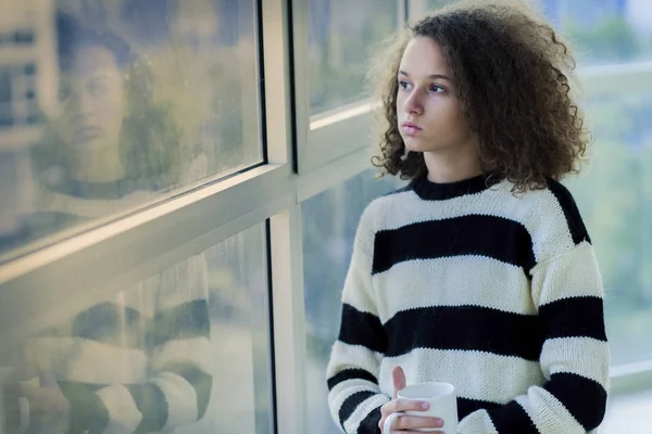 Серйозна дівчина-підліток сидить біля вікна — стокове фото