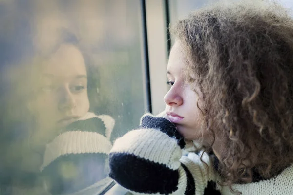 Серйозна дівчина-підліток сидить біля вікна — стокове фото
