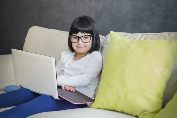 Pelo negro niña con gafas usando su portátil — Foto de Stock