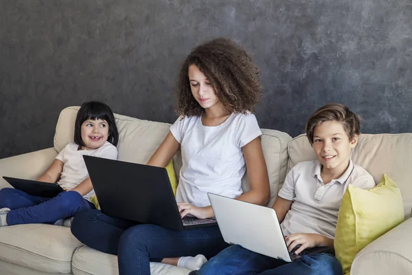 Маленька дівчинка, підліток хлопчик і кучеряве волосся дівчина бездротовий планшет і ноутбук — стокове фото