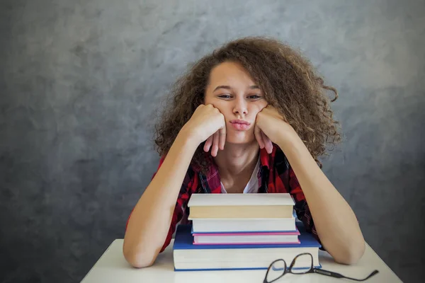 Krullend haar tiener meisje rest van leren op boeken — Stockfoto