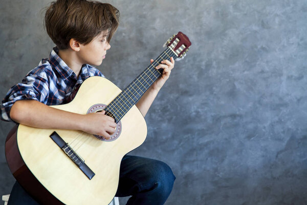 Teenage boy playing his  guitar