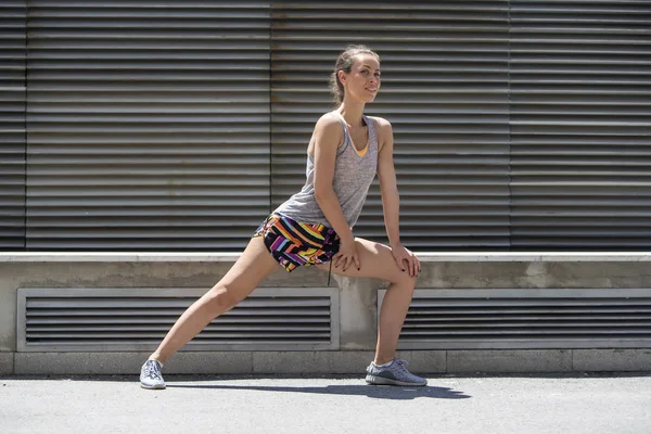Giovane donna pratica stretching dopo il jogging — Foto Stock