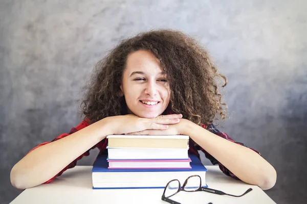 Joyeux cheveux bouclés adolescent fille reposant sur des livres — Photo
