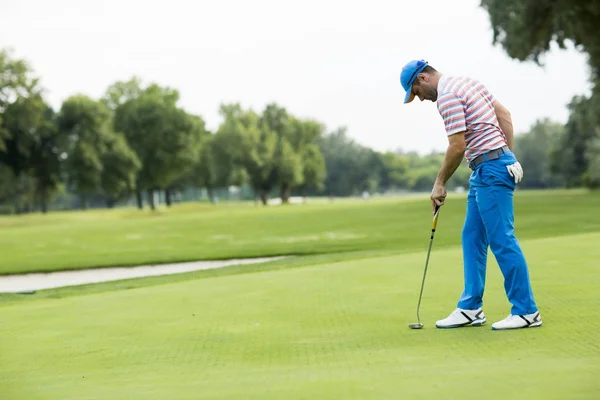 Человек играет в гольф на поле для гольфа — стоковое фото