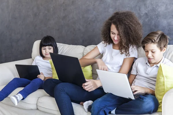 Little girl, teen boy and curly hair girl with tablet and laptop — Stock Photo, Image