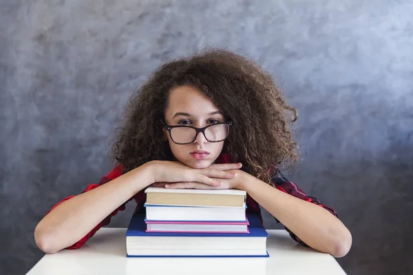 Krullend haar tiener meisje rest van leren op boeken — Stockfoto