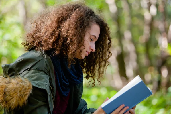 Adolescente chica leyendo libro en otoño parque — Foto de Stock