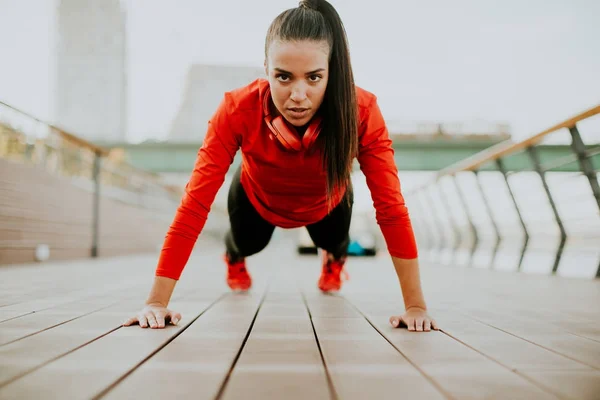 Jovem mulher exercícios no calçadão depois de correr — Fotografia de Stock