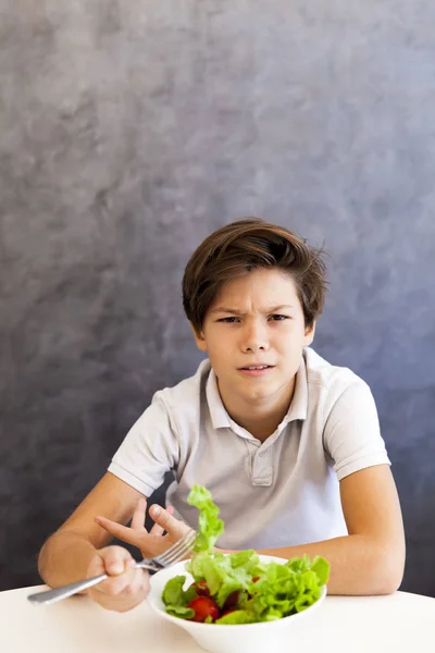 Adolescente chico se niega a comer ensalada — Foto de Stock