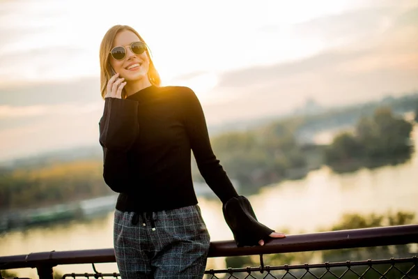 Mujer joven con teléfono móvil al aire libre — Foto de Stock