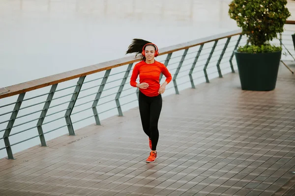 Attiva giovane bella donna che corre sul lungomare — Foto Stock