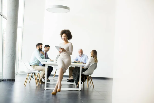 Mujer africana sonriente usando una tableta en la oficina —  Fotos de Stock