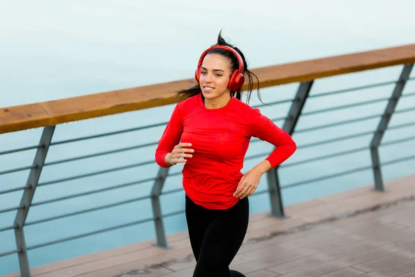 Attiva giovane bella donna che corre sul lungomare — Foto Stock